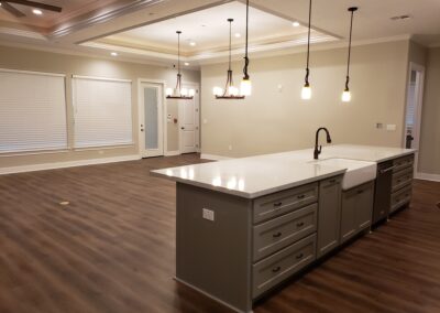 view of open concept gray with white quartz kitchen island with living and dining room behind it