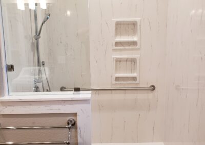 white with silver fixtures accessible shower with stability handles looking in from the doorway