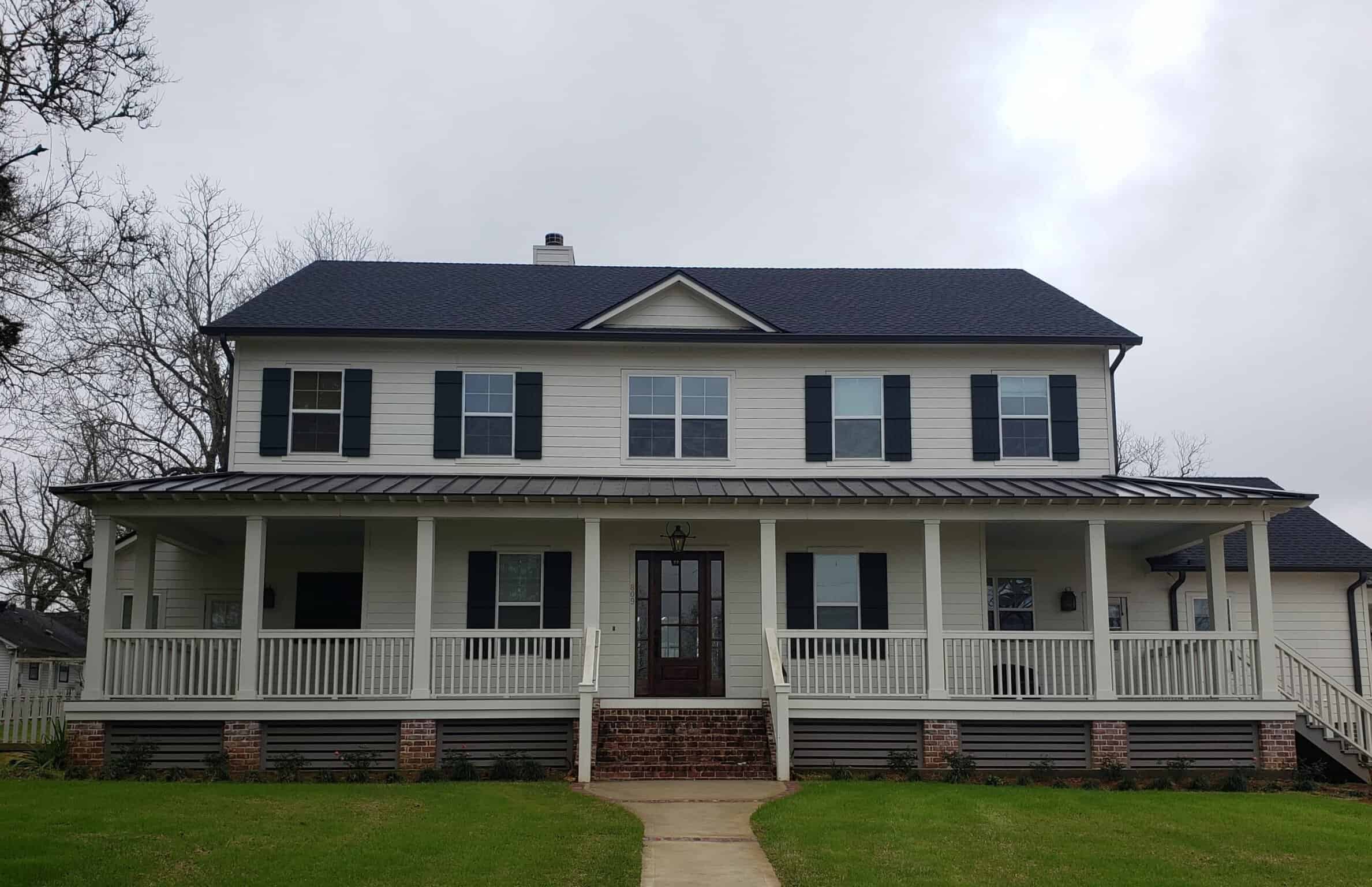 Dreams 2 Reality Custom Homes - Thompson Home Front Exterior white wood home with long front porch and brick stairs leading to front door