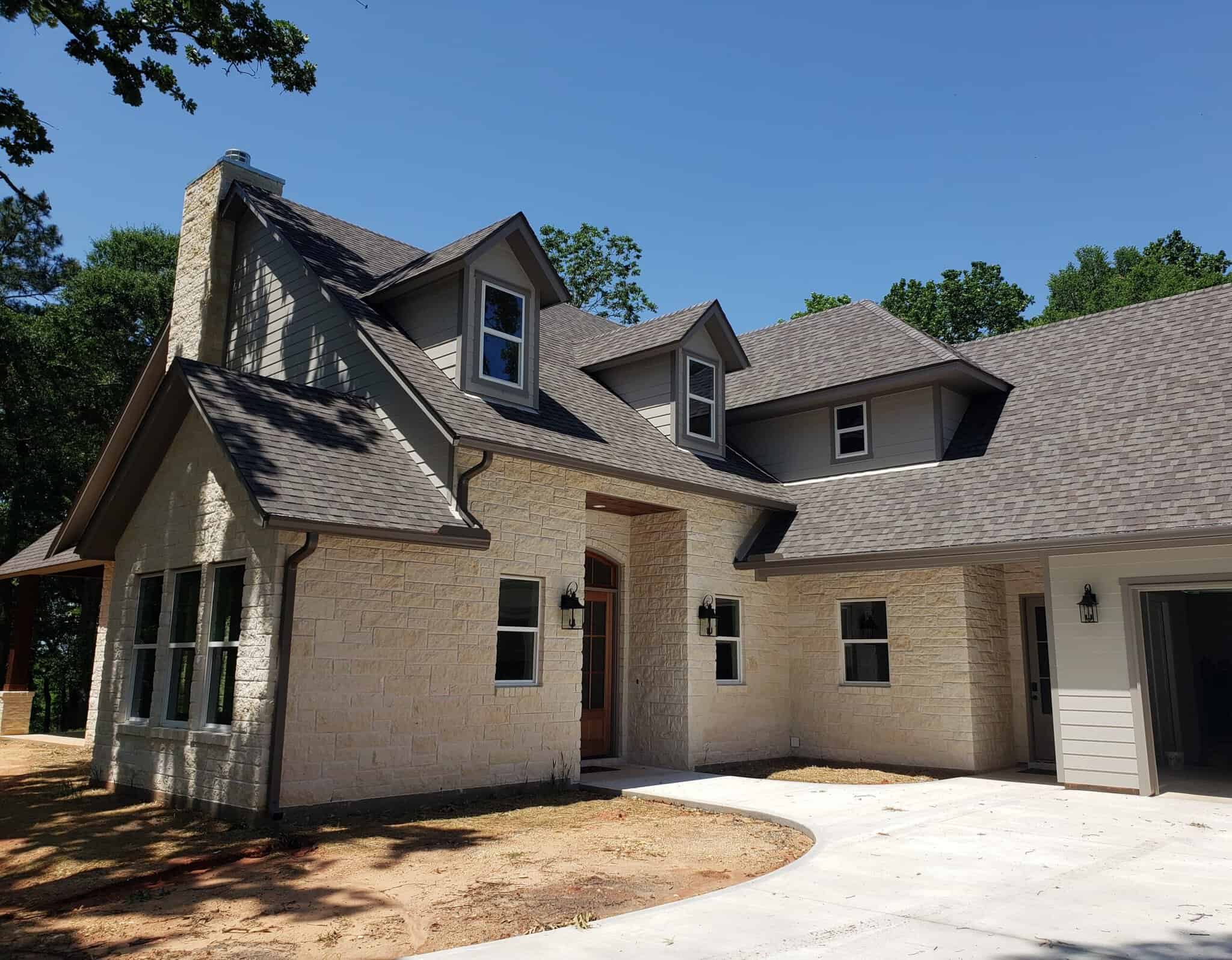 Dreams 2 Reality Custom Homes - Soul Home Front Exterior white stone two story house with dark gray roof