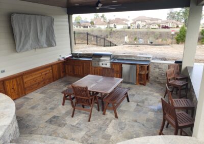 Synder custom home pool cabana lounge area with outdoor kitchenette with mounted tv and sained wood ceilings